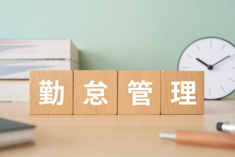 勤怠管理と書かれたブロックが置かれたデスク